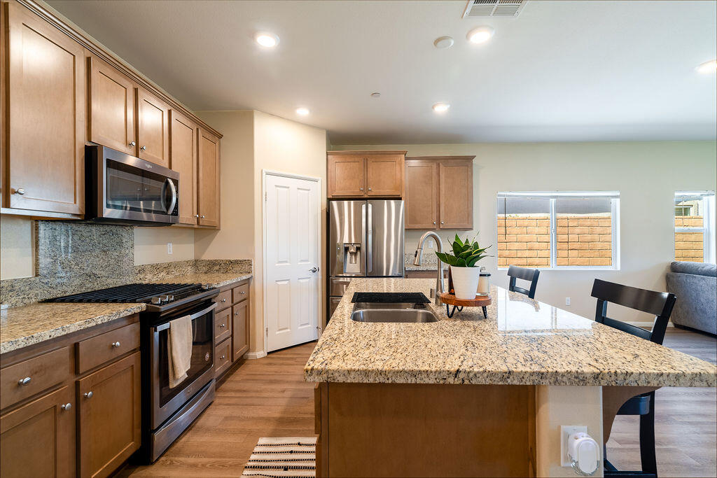 67470 Rio Naches Road Cathedral City, CA 92234 - Photo 4 of 32 a kitchen with stainless steel appliances granite countertop a stove a sink a microwave a refrigerator and cabinets