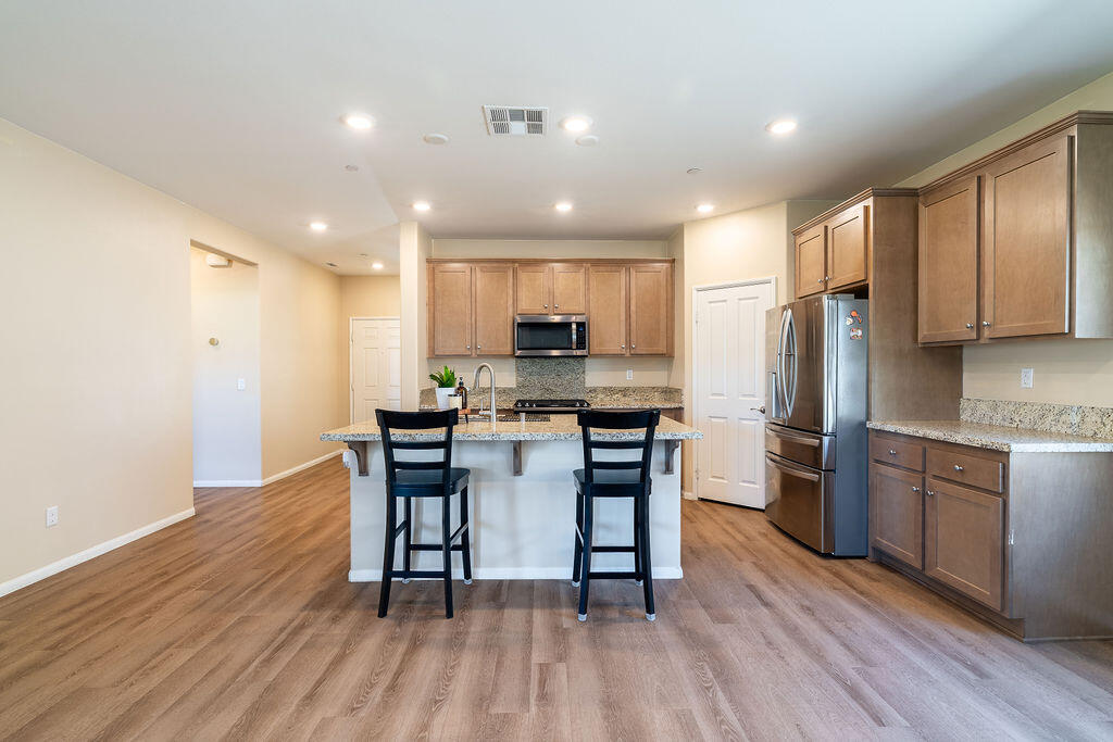 67470 Rio Naches Road Cathedral City, CA 92234 - Photo 6 of 32 a kitchen with kitchen island granite countertop wooden floors and stainless steel appliances