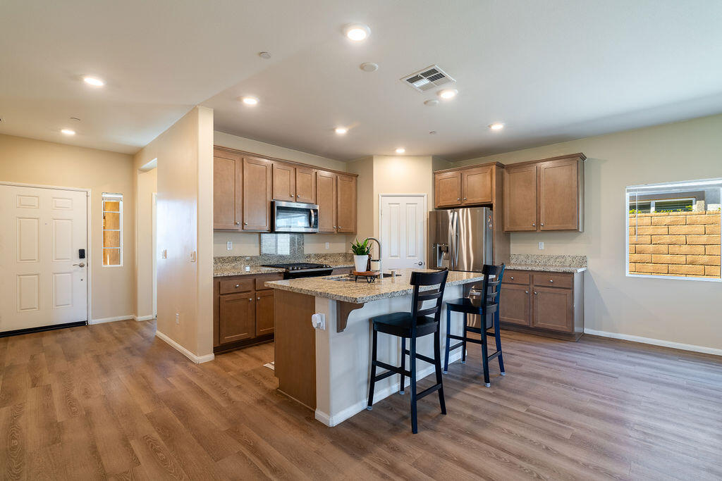 67470 Rio Naches Road Cathedral City, CA 92234 - Photo 7 of 32 a kitchen with a sink cabinets stainless steel appliances and wooden floor