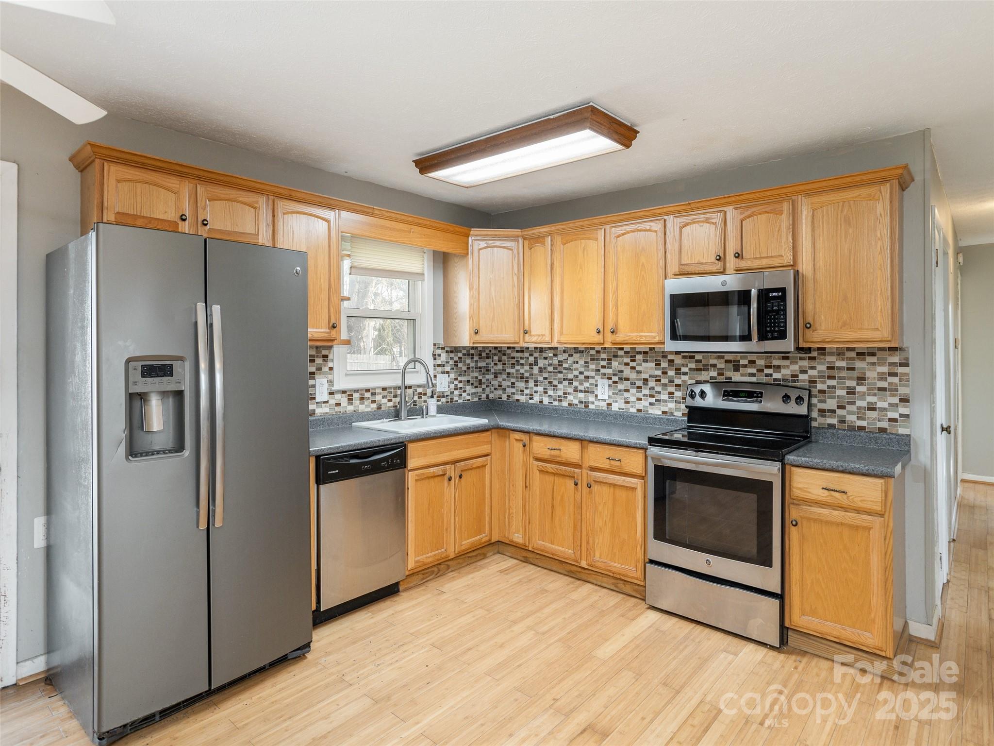 5057 Howard Gap Road Flat Rock, NC 28731 - Photo 6 of 19 a kitchen with granite countertop a refrigerator stove top oven and sink