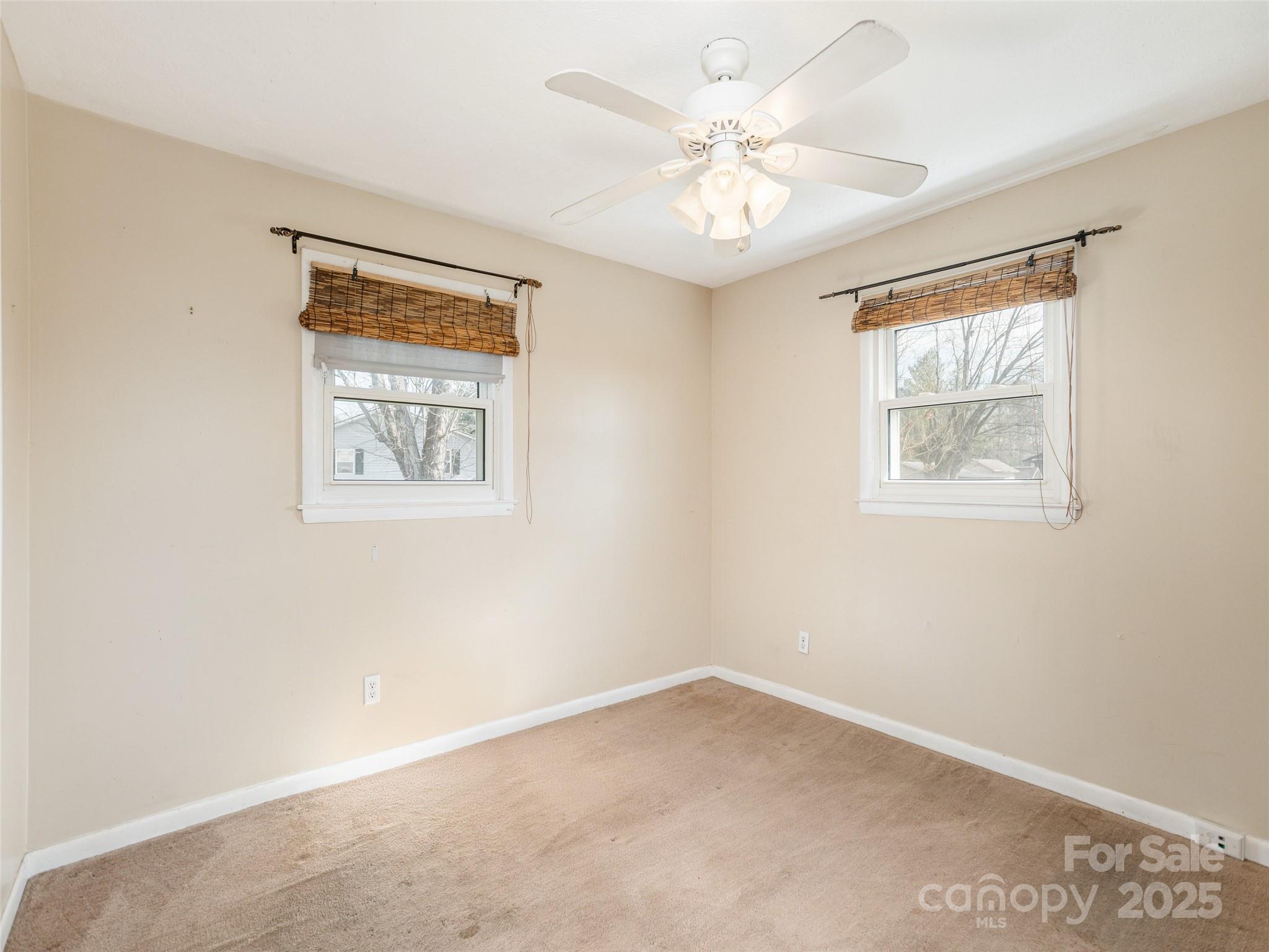 5057 Howard Gap Road Flat Rock, NC 28731 - Photo 10 of 19 an empty room with windows and fan