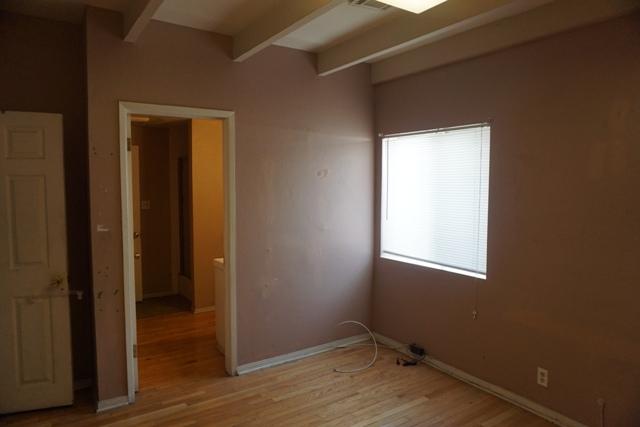 44822 Genoa Avenue Lancaster, CA 93534 - Photo 12 of 27 a view of an empty room with wooden floor and a window