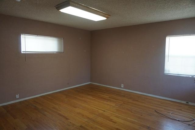 44822 Genoa Avenue Lancaster, CA 93534 - Photo 13 of 27 a view of an empty room with wooden floor and a window