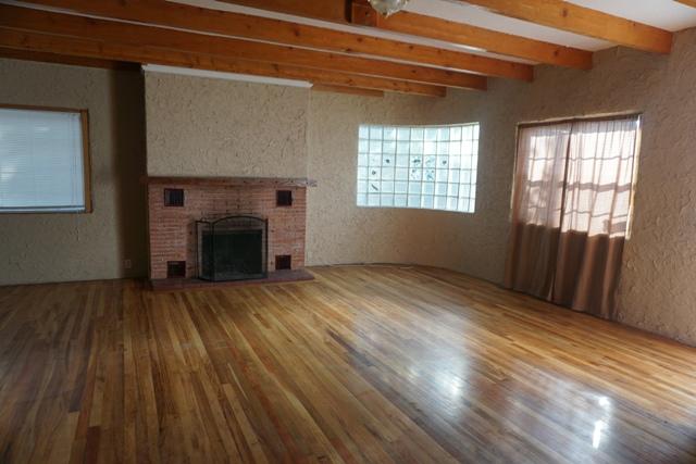 44822 Genoa Avenue Lancaster, CA 93534 - Photo 3 of 27 a view of an empty room with wooden floor and a window