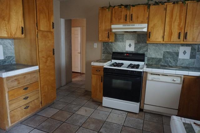 44822 Genoa Avenue Lancaster, CA 93534 - Photo 6 of 27 a kitchen with white cabinets and a stove top oven