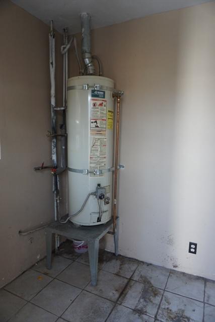 44822 Genoa Avenue Lancaster, CA 93534 - Photo 8 of 27 a room with water heater and wooden cabinets