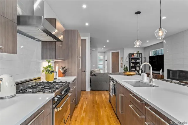 a kitchen with stainless steel appliances granite countertop a sink stove and refrigerator