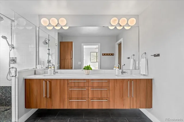 a bathroom with a sink a large mirror and a shower