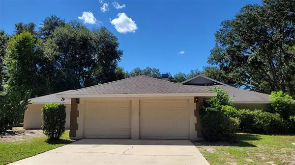 a view of a house with backyard and tree