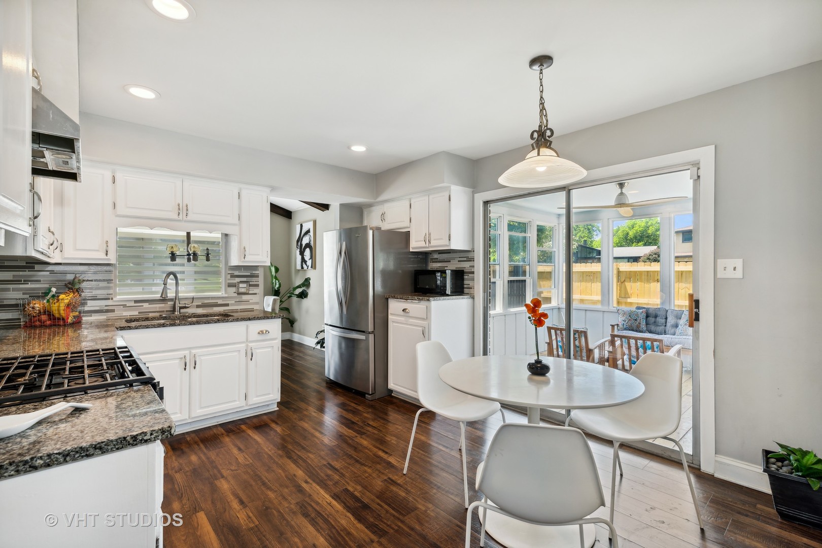 18724 Loomis Avenue Homewood, IL 60430 - Photo 5 of 11 a kitchen with stainless steel appliances granite countertop a stove a refrigerator a sink a dining table and chairs with wooden floor
