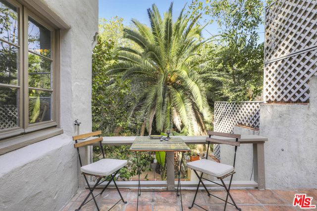 a view of a patio with couches table and chairs and potted plants