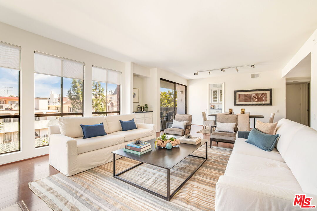 11805 Mayfield Avenue, Unit 202 Los Angeles, CA 90049 - Photo 1 of 17 a living room with furniture wooden floor and a large window