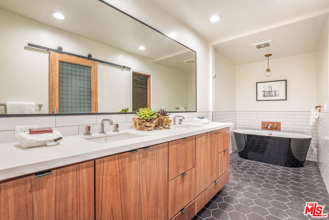 11805 Mayfield Avenue, Unit 202 Los Angeles, CA 90049 - Photo 10 of 17 a bathroom with a tub sink and mirror