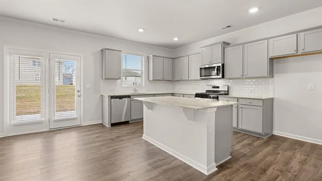 a kitchen with granite countertop white cabinets and a sink