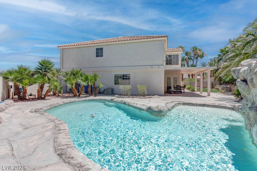 1 Rising Sun Court Henderson, NV 89074 - Photo 43 of 47 An inviting backyard oasis offers a sparkling pool and a covered patio for al fresco entertaining.