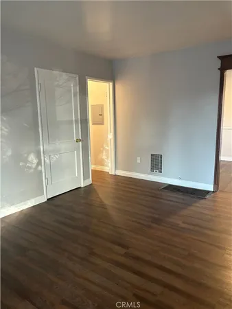 an empty room with wooden floor and closet