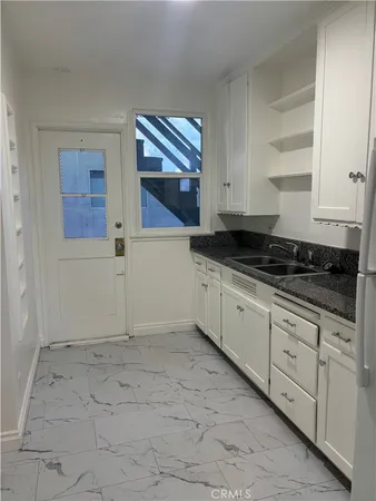 a kitchen with kitchen island white cabinets and stainless steel appliances
