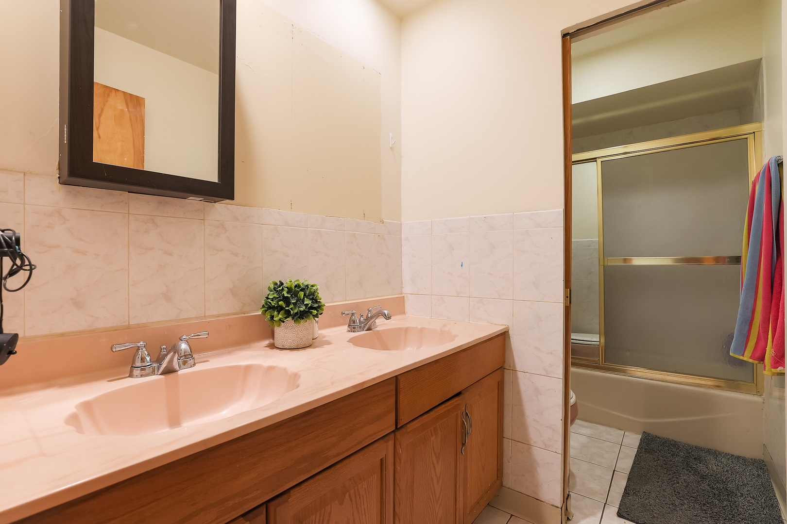 9461 Dee Road Des Plaines, IL 60016 - Photo 11 of 26 a bathroom with a double vanity sink and a mirror