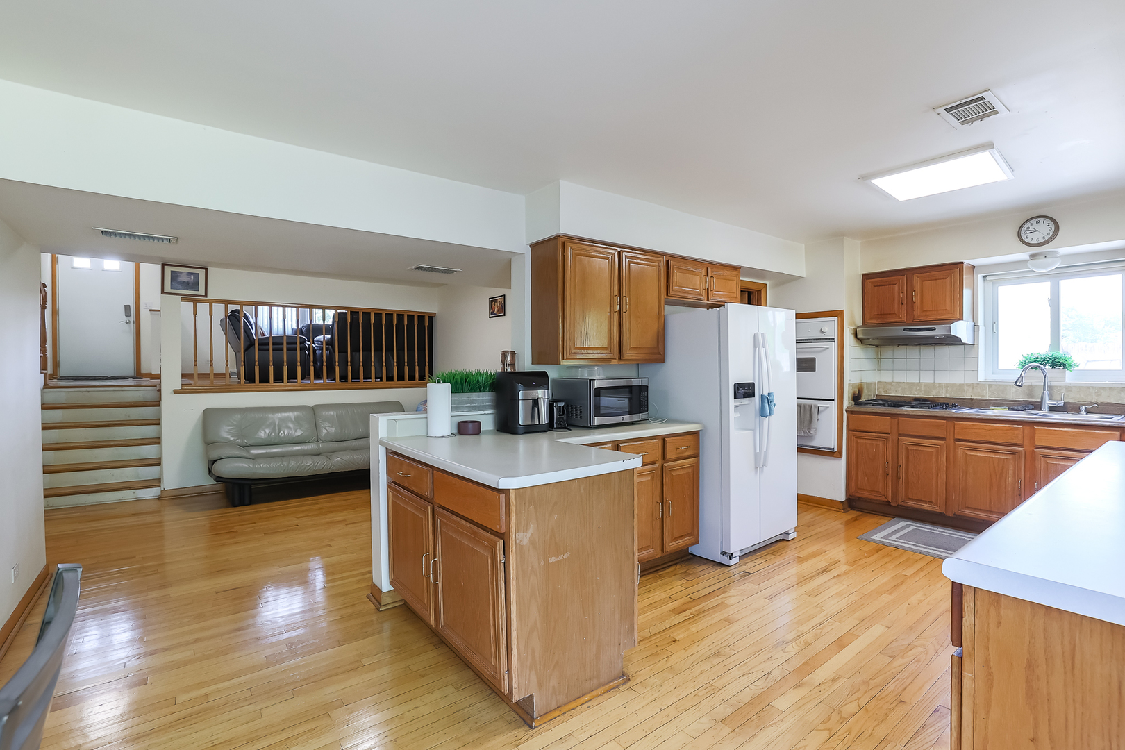 9461 Dee Road Des Plaines, IL 60016 - Photo 17 of 26 a kitchen with stainless steel appliances a stove a sink dishwasher a refrigerator white cabinets and wooden floor