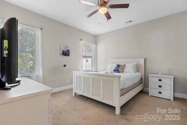 a white bed sitting in a bedroom next to a window