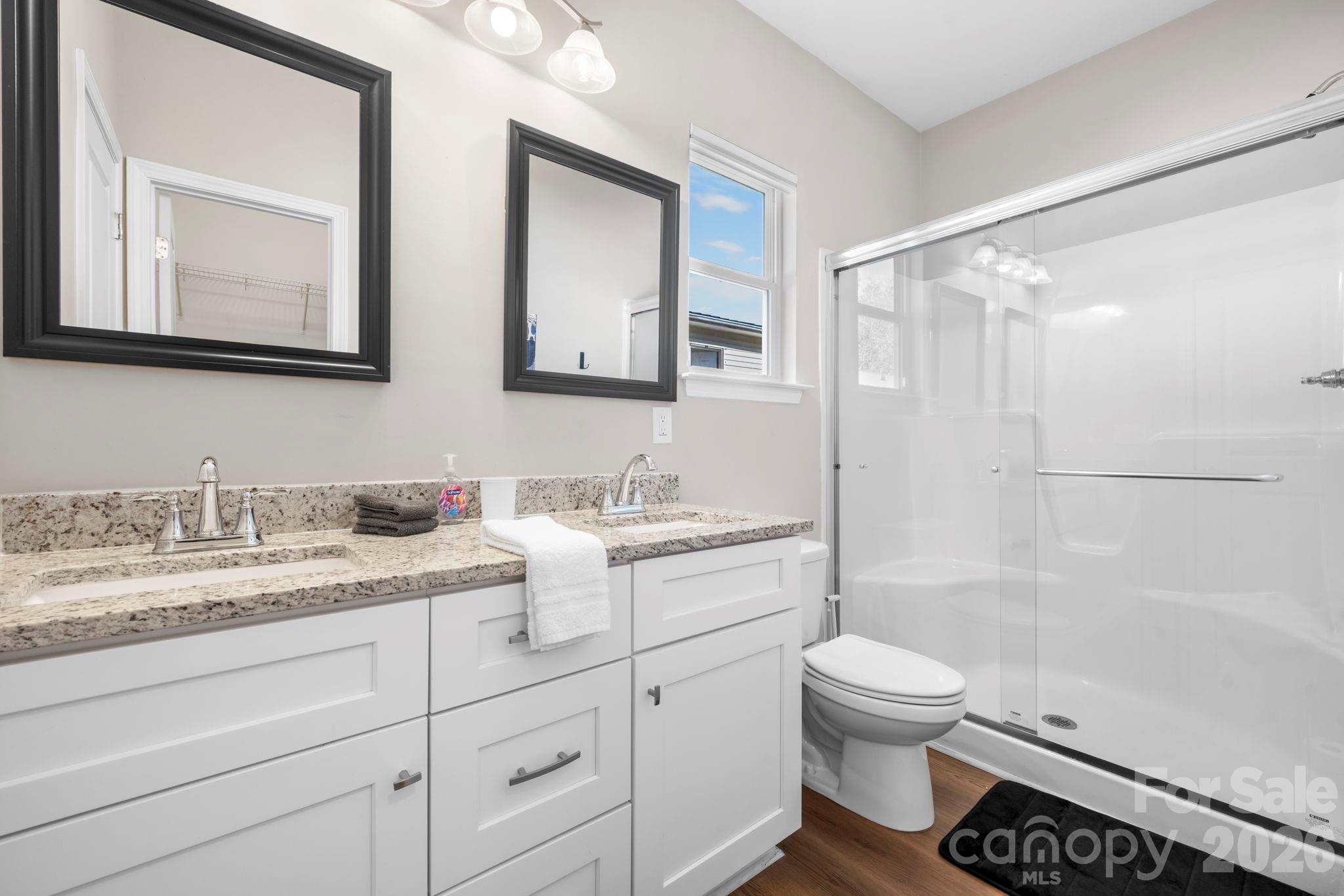 402 2nd Street Southwest Hickory, NC 28602 - Photo 12 of 24 a bathroom with a granite countertop sink toilet mirror and shower