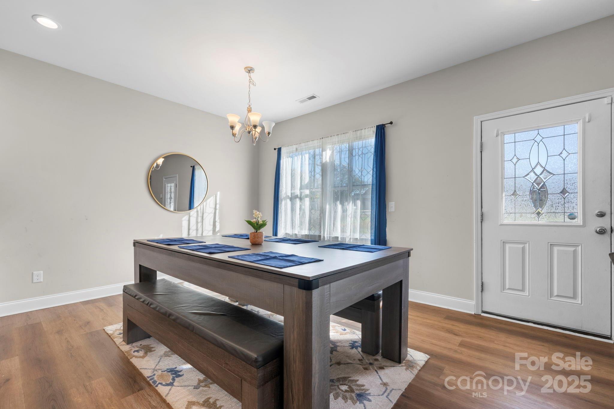 402 2nd Street Southwest Hickory, NC 28602 - Photo 5 of 24 a dining room with wooden floor a chandelier a wooden table and chairs