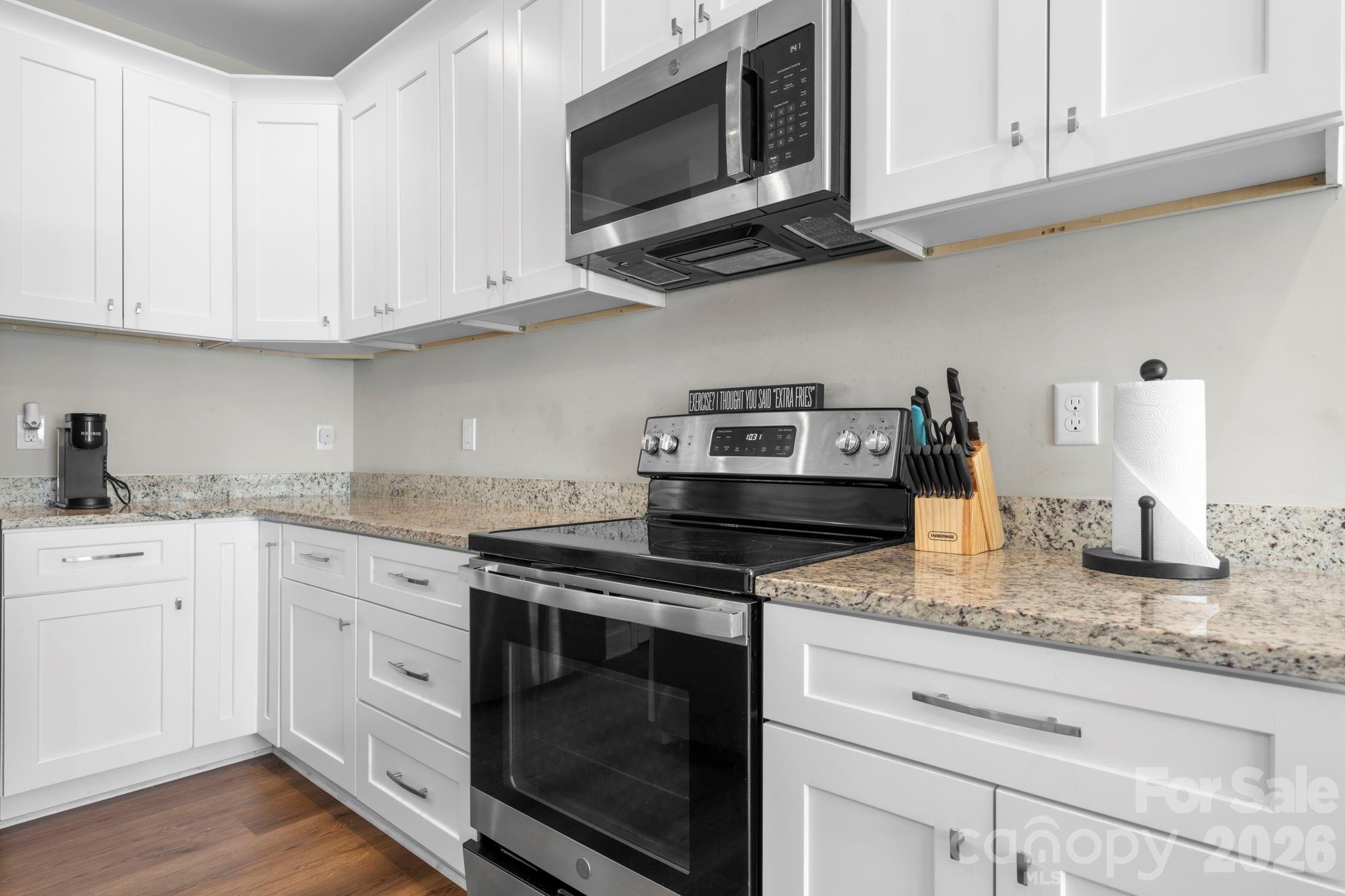 402 2nd Street Southwest Hickory, NC 28602 - Photo 6 of 24 a kitchen with stainless steel appliances granite countertop white cabinets stove a sink and dishwasher