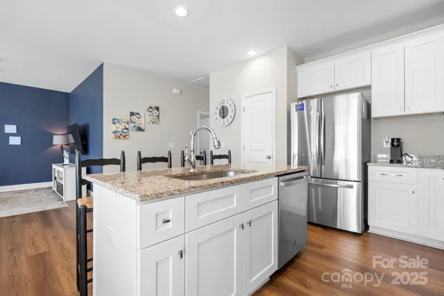 a kitchen with white cabinets and stainless steel appliances