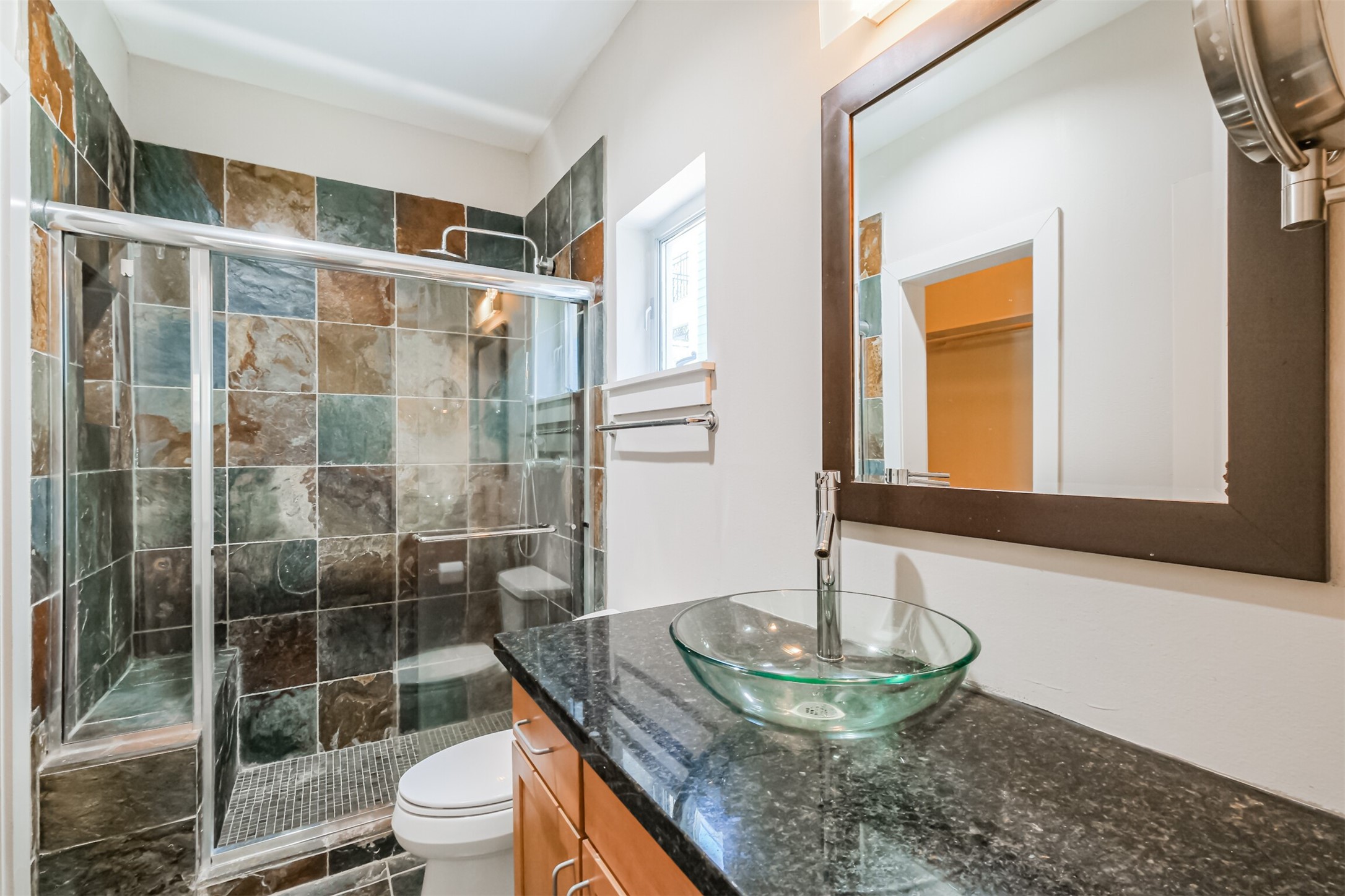 2364 Arlington Street Houston, TX 77008 - Photo 10 of 45 a bathroom with a granite countertop toilet a sink and a mirror