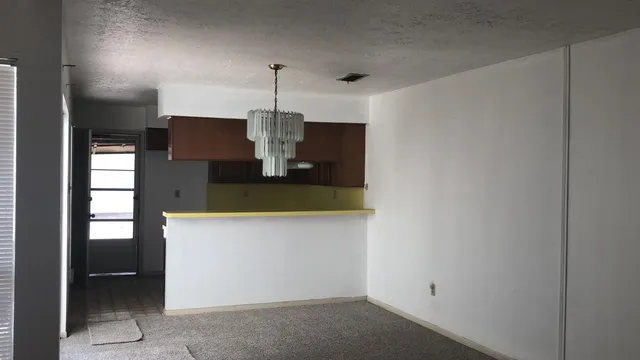 a view of a kitchen with a refrigerator and a sink
