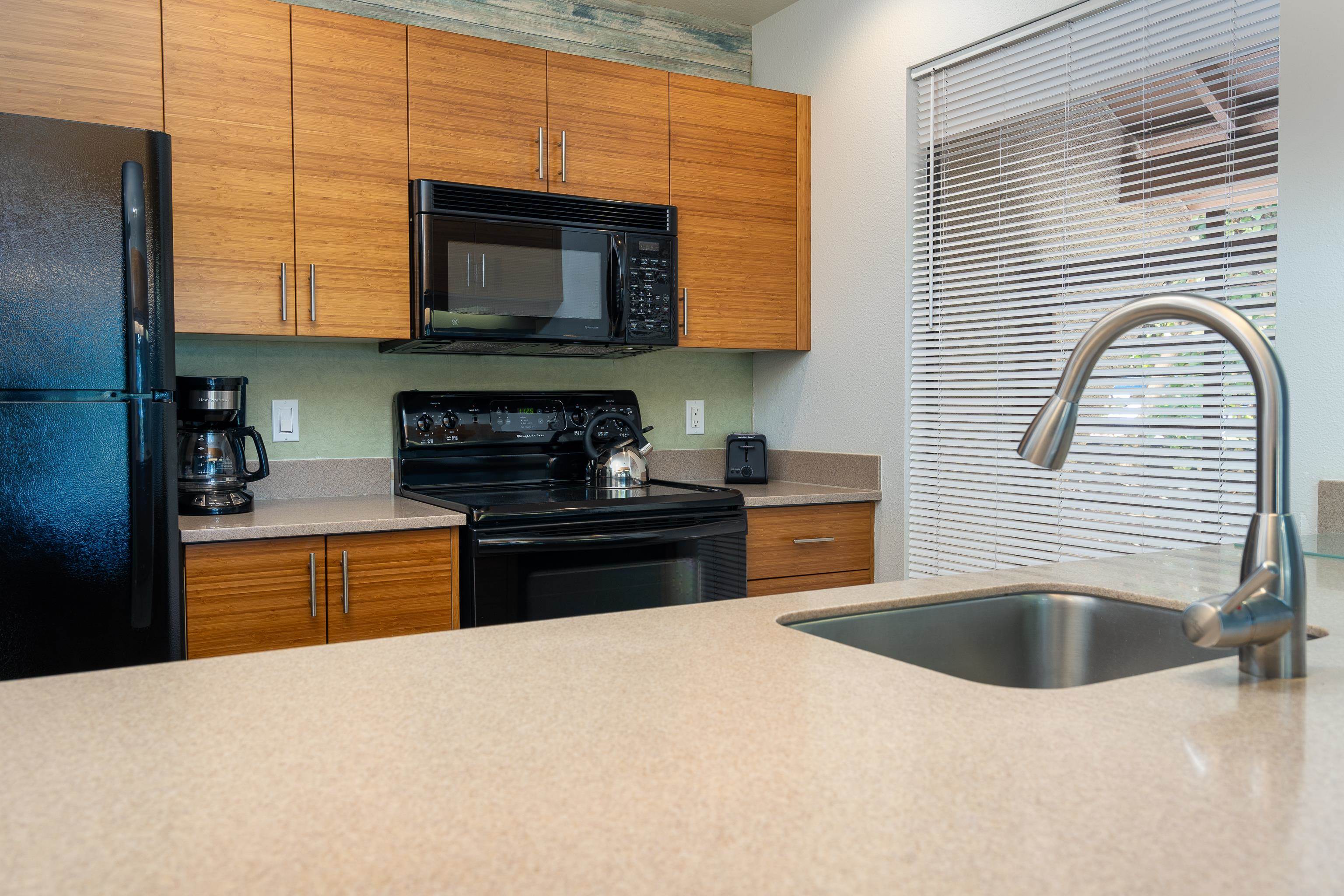 2777 South Kihei Road, Unit G101 Kihei, HI 96753 - Photo 8 of 32 a kitchen with granite countertop a sink and a stove top oven