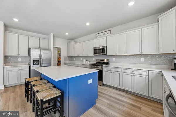 a kitchen with a sink stove top oven and refrigerator