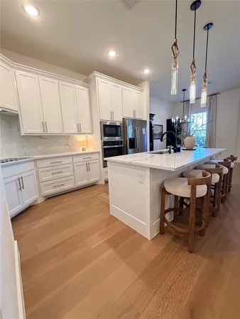 a kitchen with kitchen island a stove a table and chairs in it