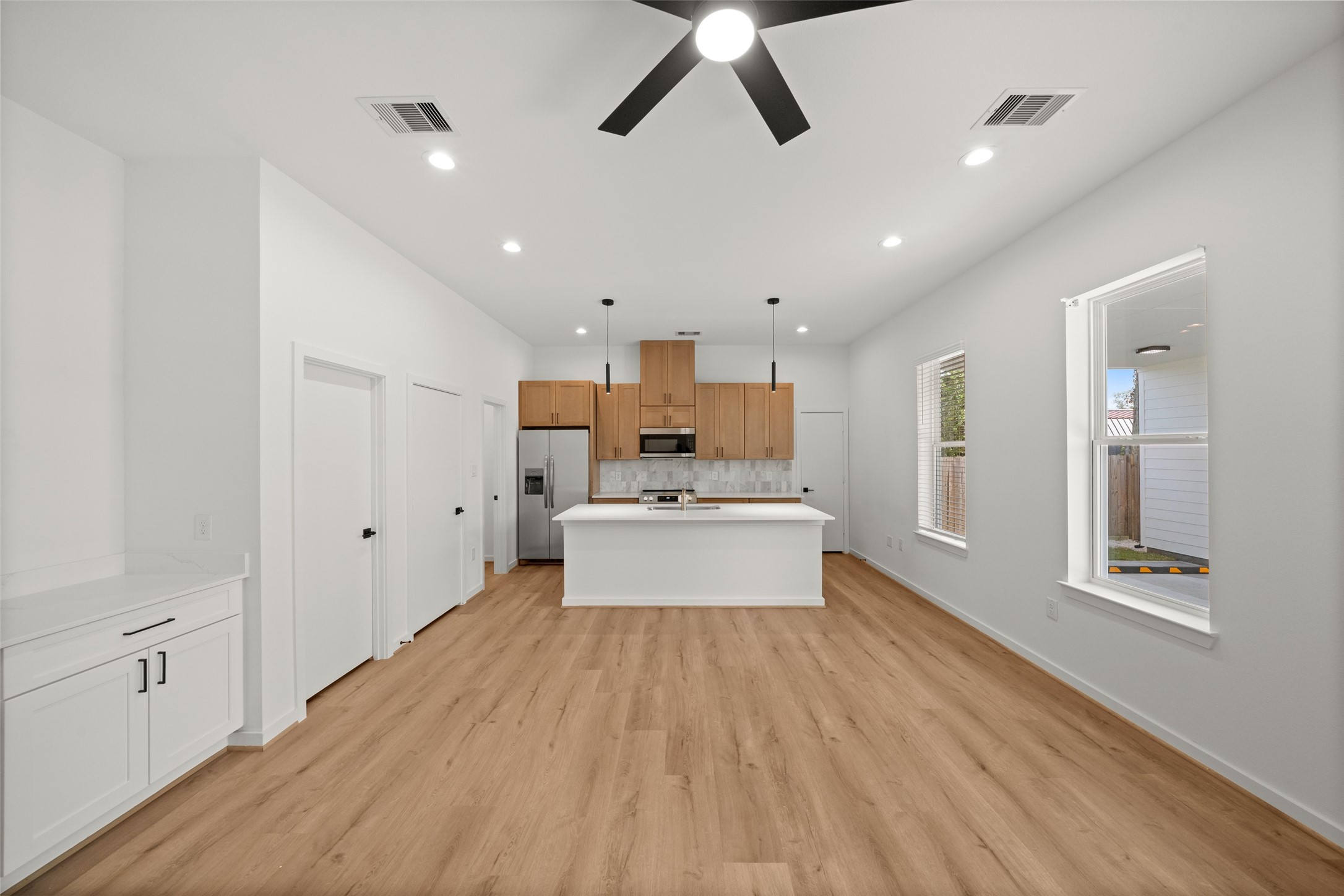 1408 Enid Street, Unit C Houston, TX 77009 - Photo 7 of 27 a large kitchen with stainless steel appliances kitchen island a large counter space a sink and a window