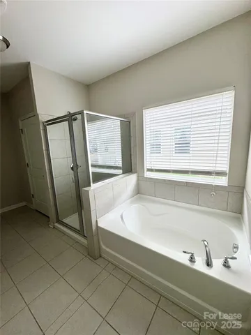 a spacious bathroom with bathtub and a shower