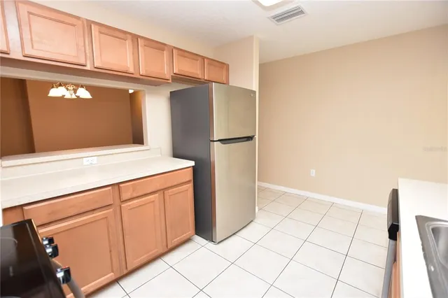 a kitchen with white cabinets and refrigerator