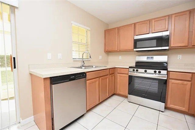 a kitchen with stainless steel appliances granite countertop a sink and a microwave