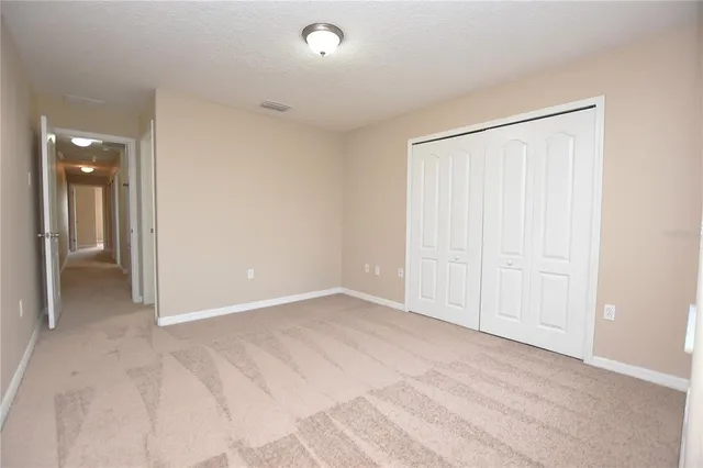 an empty room with closet and a bathroom