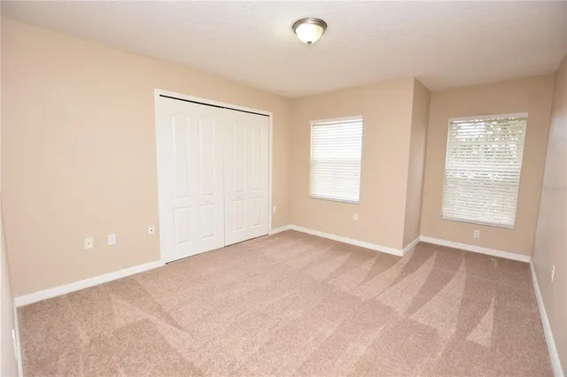 an empty room with windows and closet