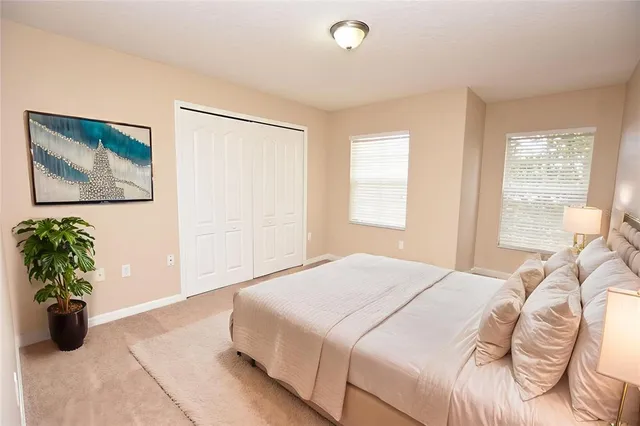 a bedroom with a bed and a potted plant