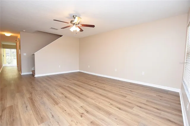 a view of a room with wooden floor and a ceiling fan