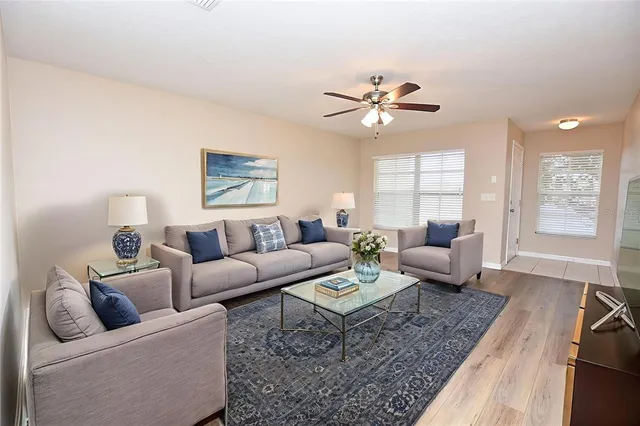 a living room with furniture ceiling fan and a rug
