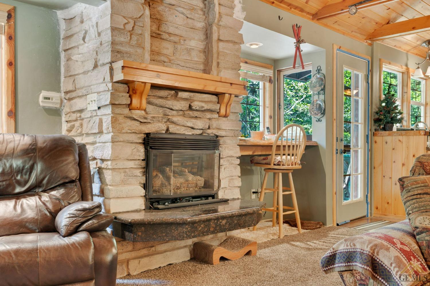 Undisclosed Address Posey, CA 93260 - Photo 14 of 50 a living room with furniture a fireplace and a floor to ceiling window