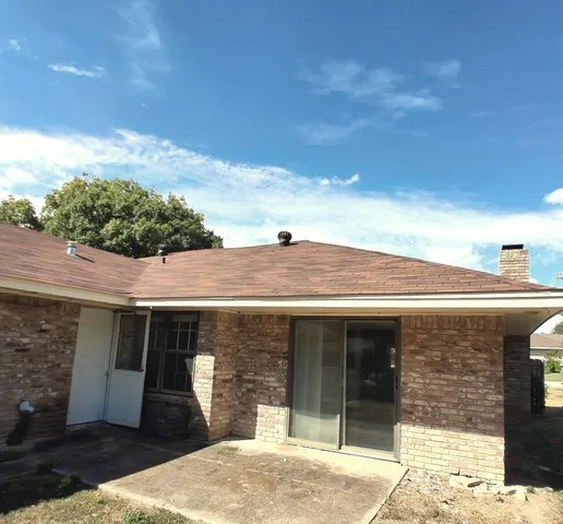 a view of a brick house with potted plants