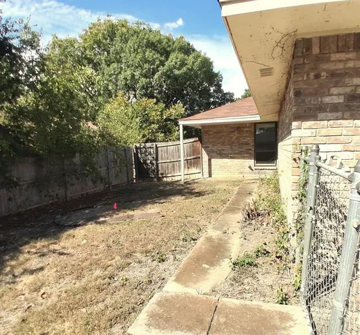 a backyard of a house with a large tree