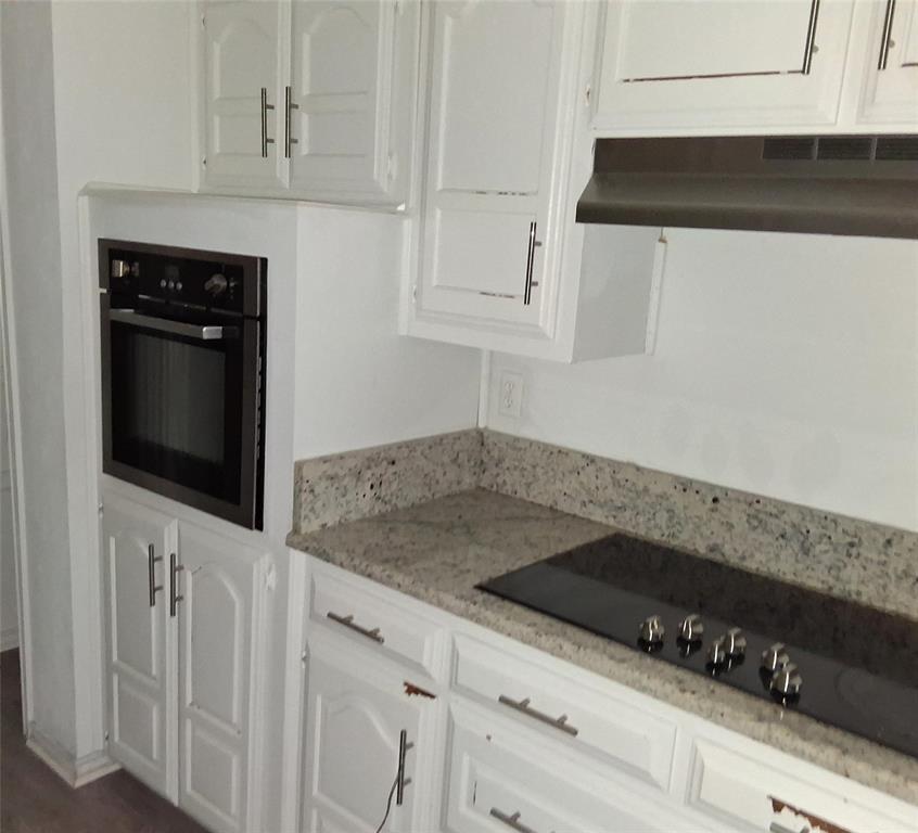 814 Oakbluff Drive Lancaster, TX 75146 - Photo 5 of 17 a kitchen with white cabinets and black appliances