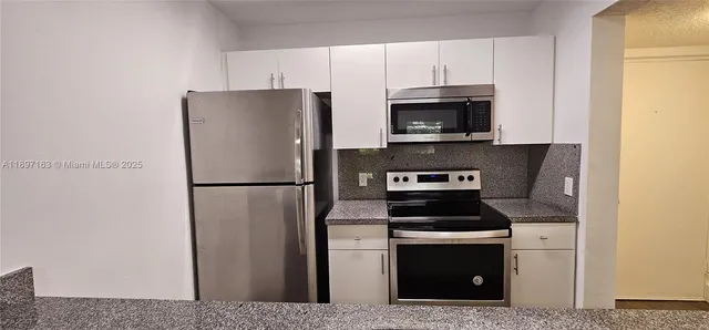 a kitchen with a refrigerator stove and microwave