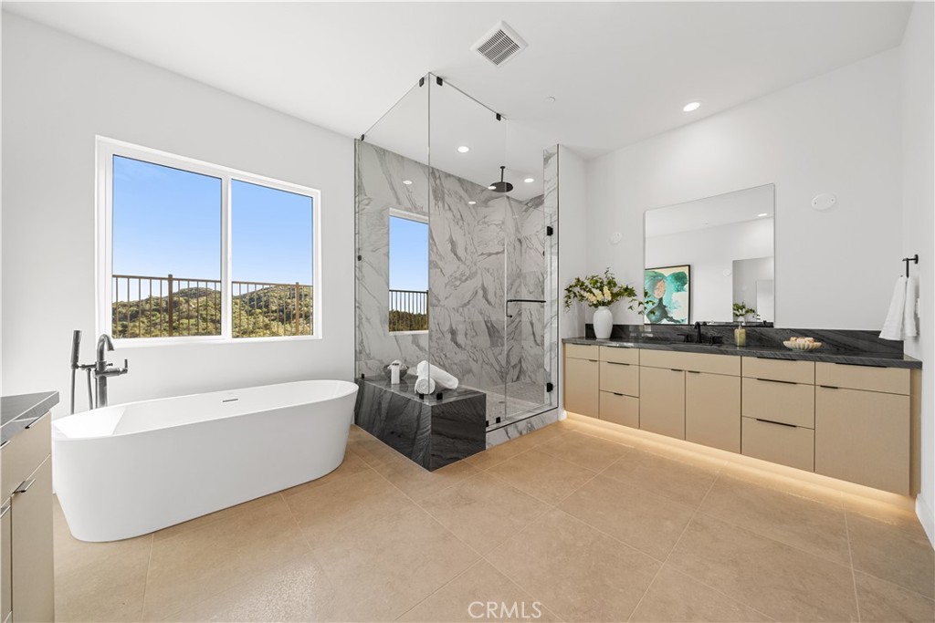 18302 Saddle Crest Silverado, CA 92676 - Photo 17 of 40 a spacious bathroom with a large tub shower and windows