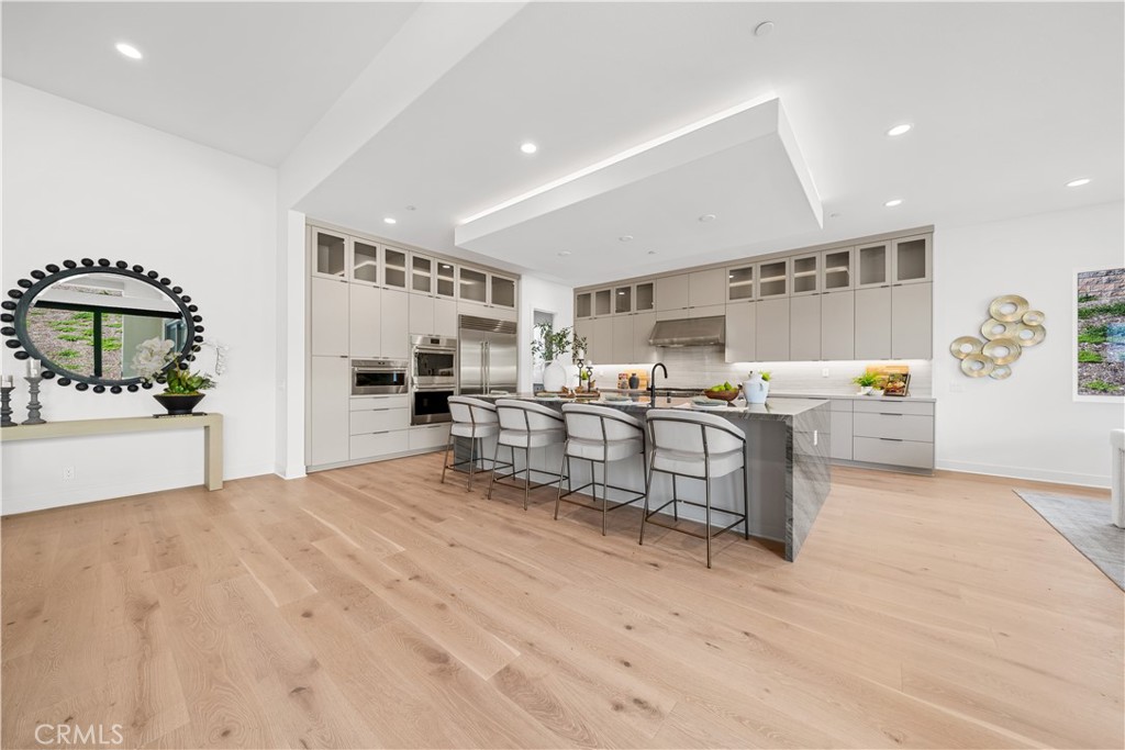 18302 Saddle Crest Silverado, CA 92676 - Photo 8 of 40 a large white kitchen with stainless steel appliances kitchen island granite countertop a refrigerator and stove top oven