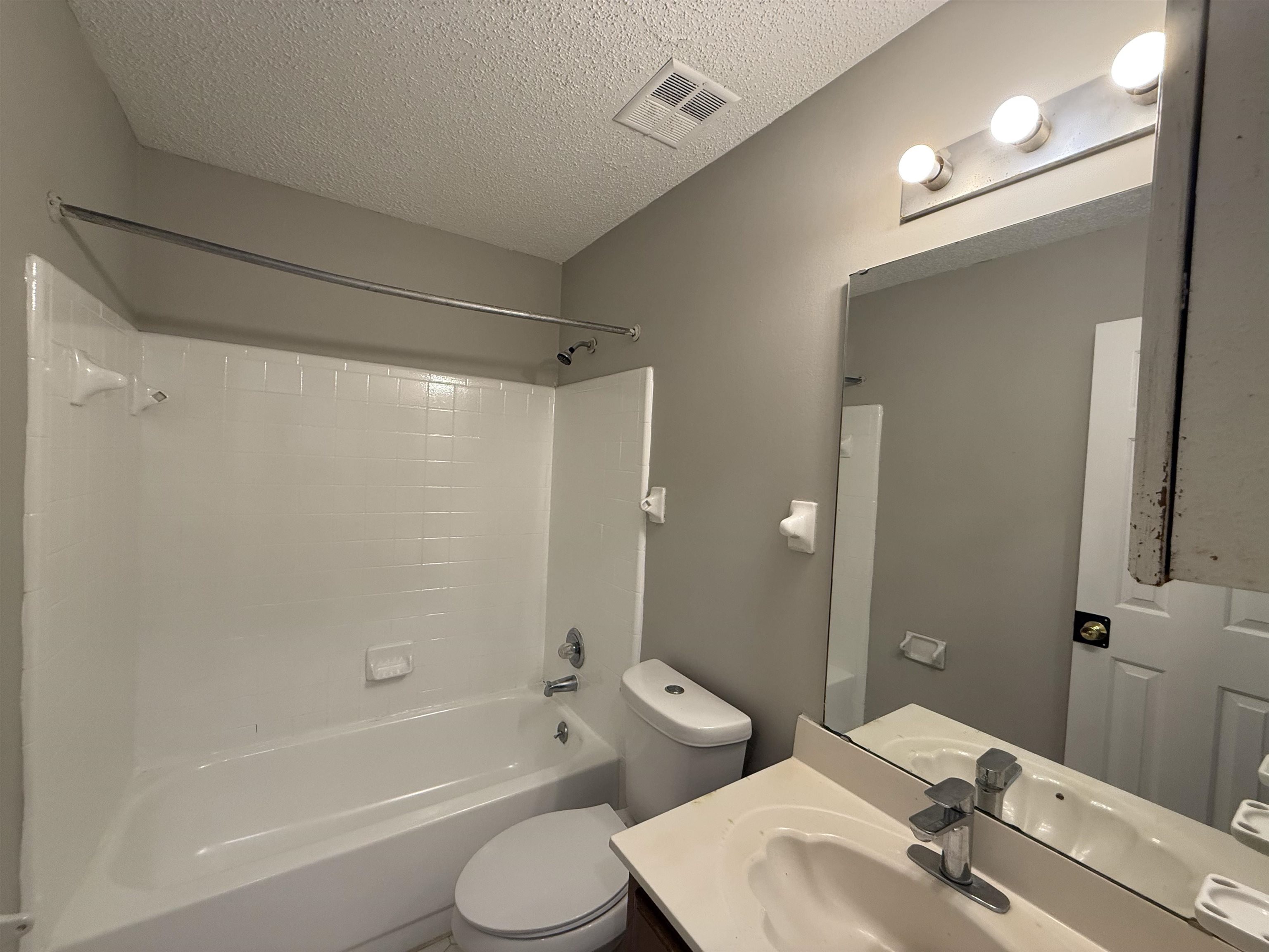 6420 Saginaw Road Memphis, TN 38134 - Photo 15 of 38 Bathroom featuring a white tub/shower combination with tiled surround, a white toilet, and a vanity with an integrated sink